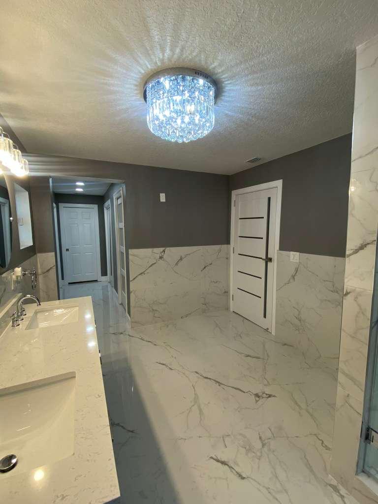 Impretto Home master bathroom in Wesley Chapel, Florida with Calacatta marble, custom vanity, and frameless glass shower